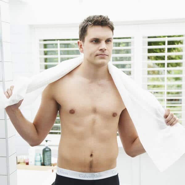Easydry white bath towel or shower towel or large towel. It is shown here in a spa or bathroom on a male model.