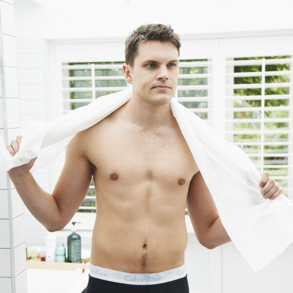 Easydry white bath towel or shower towel or large towel. It is shown here in a spa or bathroom on a male model.