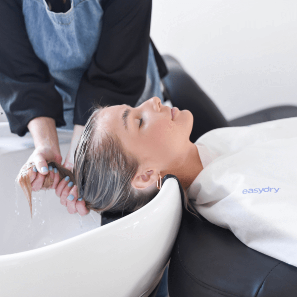 Easydry white medium disposable towel shown as a towel being wrapped into a turban on a clients hair and as a towel on the clients shoulders.
